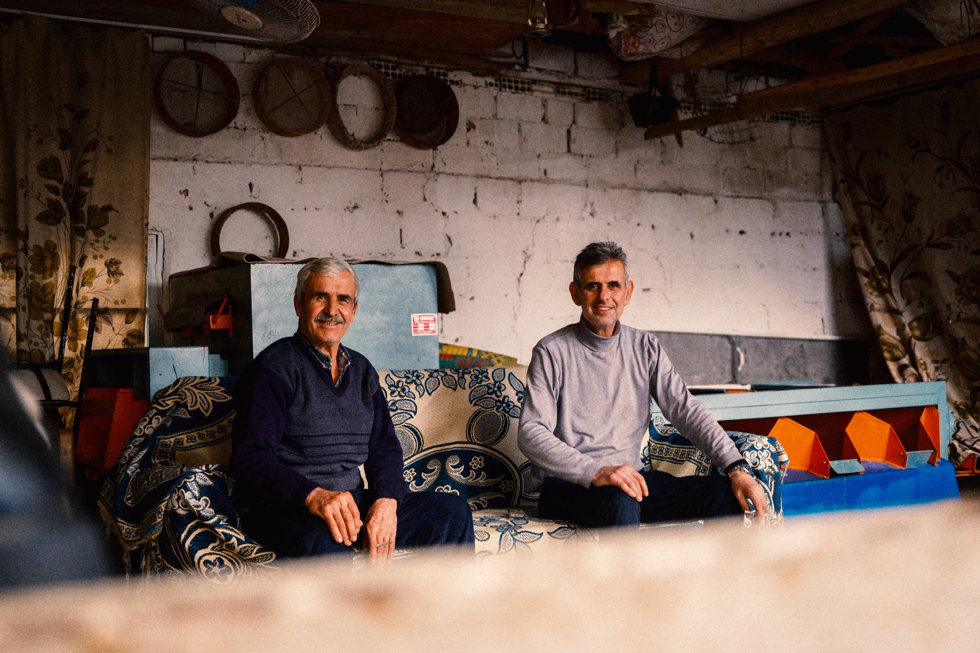 Two craftsmen seated in workshop