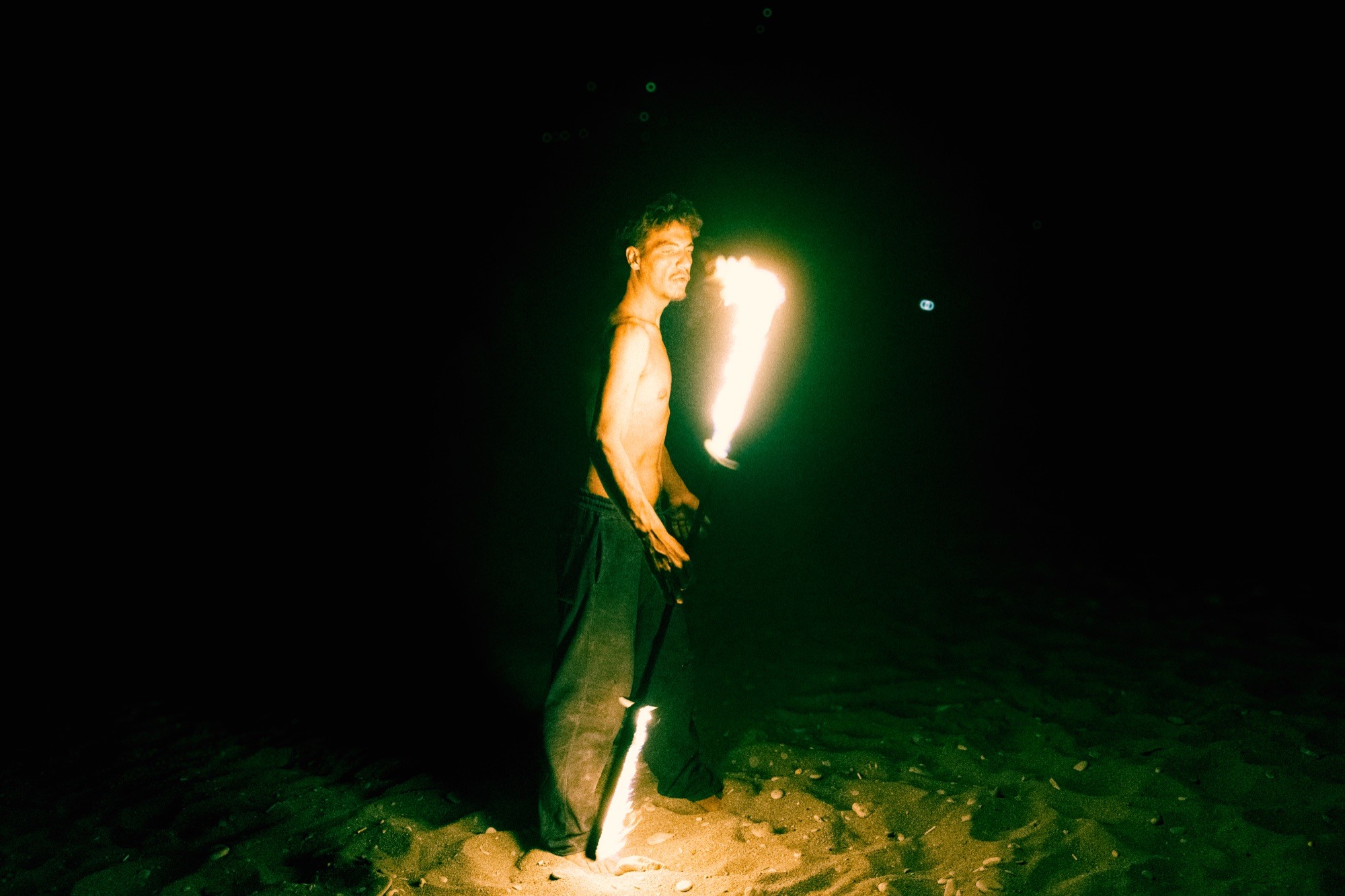 Fire performer on beach at night