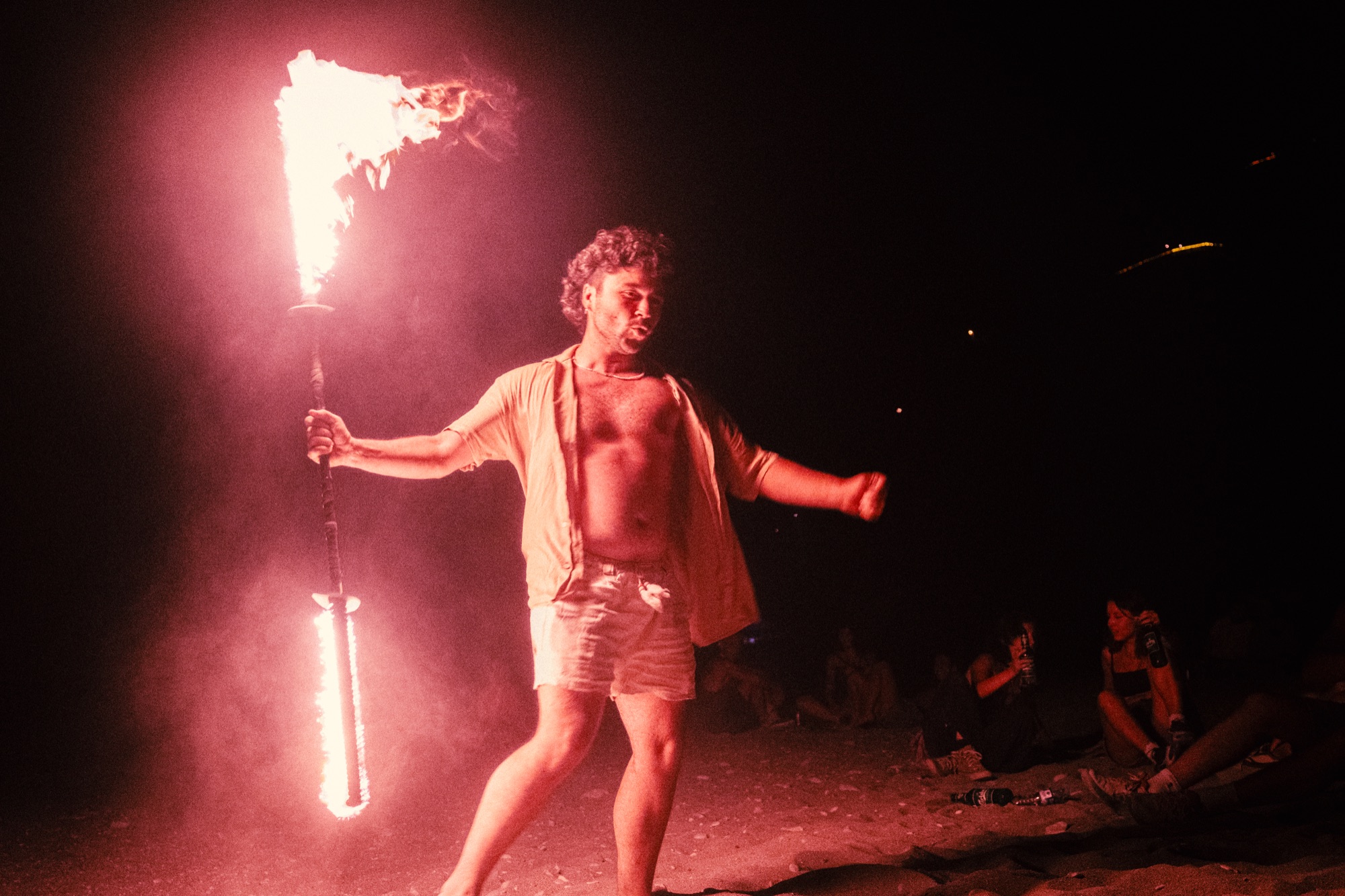 Fire performer with torch, crowd in background