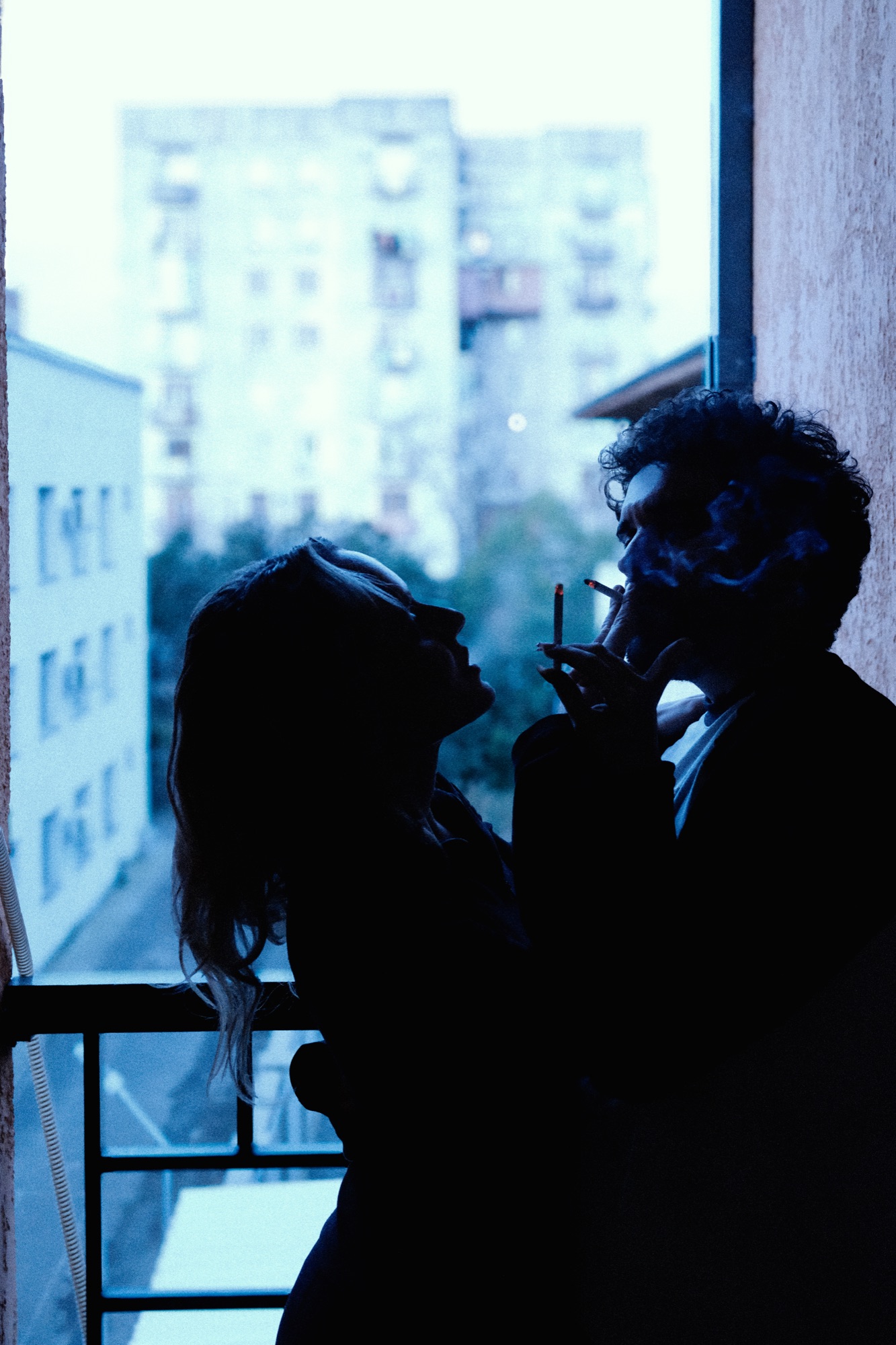 Couple silhouetted on balcony overlooking city
